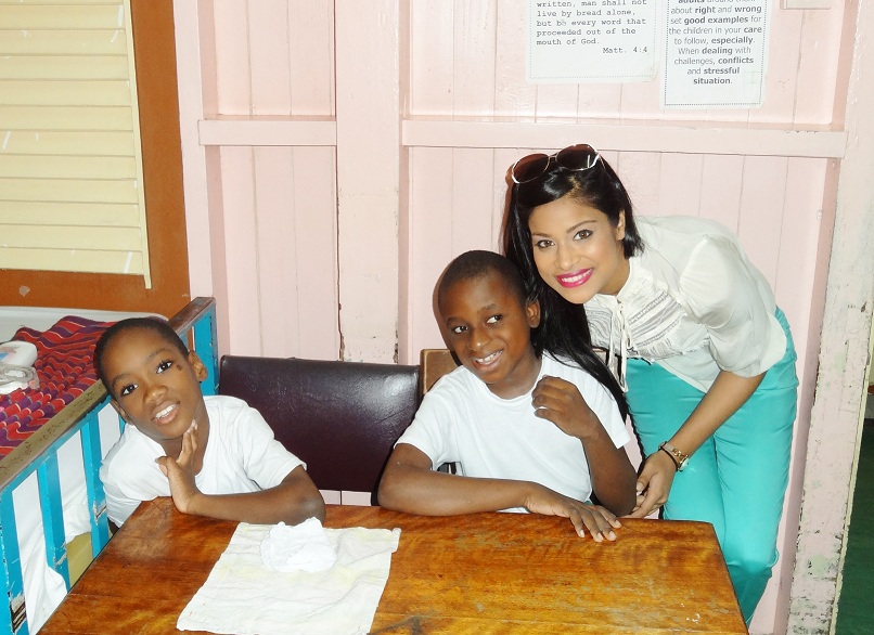 Miss Guyana India Katherina Roshana with two of the children at the Ptolemy Reid Rehabilitation Centre