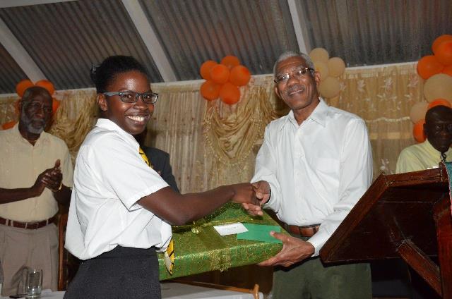 Elisa Hamilton being presented with a laptop computer by President Granger.