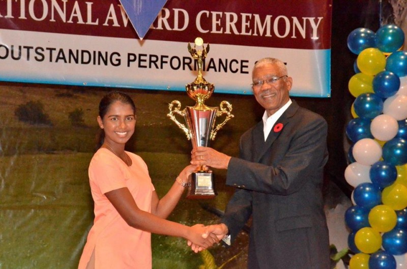 President David Granger presenting an award to Victoria Najab from the Saraswati Vidya Niketan School for the most outstanding candidate at the CSEC level in business education.